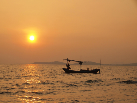 Beautiful sunset over the sea and Fishing boatの写真素材