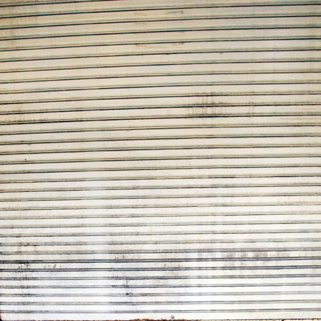 Illuminated grunge metallic roller shutter doorの写真素材