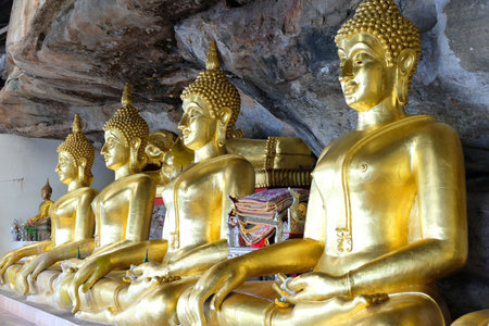 Ubon Ratchathani, Thailand - 27 January 2018: Visiting gold buddha statue in the Tham Khuha Sawan cave temple, located at a cliffのeditorial素材