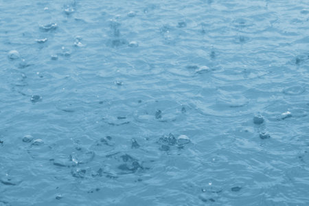 blue color tone of close up rain water drop falling to the floorの写真素材