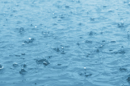 blue color tone of close up rain water drop falling to the floorの写真素材