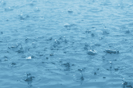 blue color tone of close up rain water drop falling to the floorの写真素材