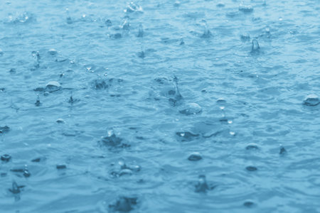 blue color tone of close up rain water drop falling to the floorの写真素材