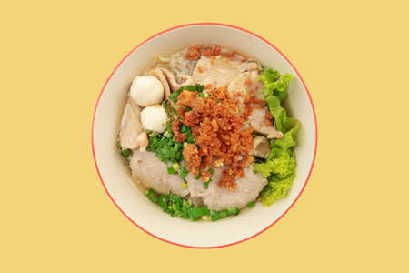 pork noodles with fried garlic on top on yellow backgroundの写真素材