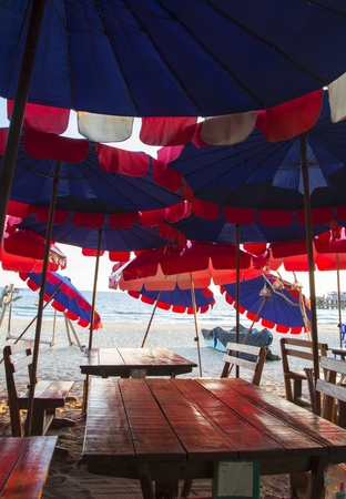 Umbrella on dining table over beachの写真素材