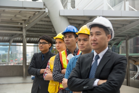 Businessmen standing in a row to present business success - focus at last three peopleの写真素材