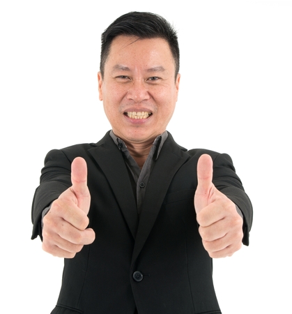 Portrait of confident businessman present confidence and success by showing two thumbs, isolated on white backgroundの写真素材