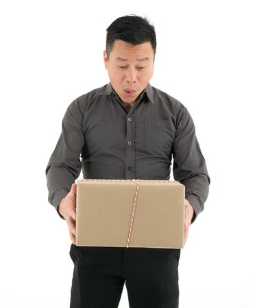 Businessman receiving and viewing a big package with surprise isolated on white backgroundの写真素材