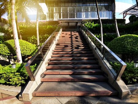 Cityscape of modern city skyline with outdoor stairs up at dusk toward the officice building with green plant and flower decoration along the way.の写真素材