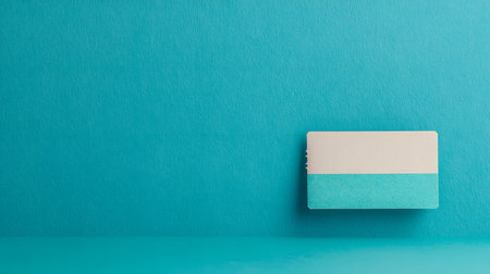 Blank business card on blue wall background. Copy space for text.の素材