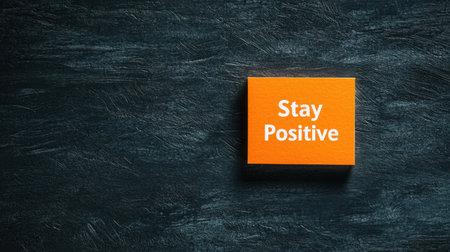 A vibrant orange block displaying the phrase "Stay Positive" against a dark textured background. This design embodies encouragement and inspiration, perfect for uplifting spaces.の素材