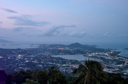 A breathtaking twilight view of a coastal city showcasing calm waters and hills under a colorful...