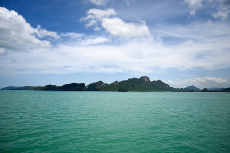 This image showcases a tranquil tropical island surrounded by clear turquoise waters under a bright...