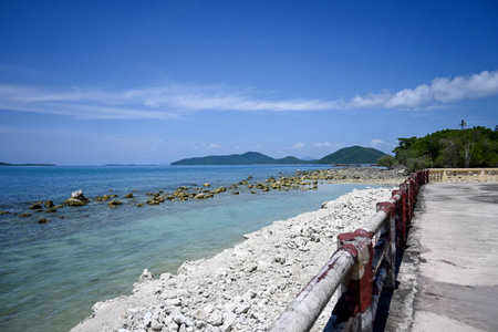 This scenic coastal view features a rocky shoreline and clear blue water under a bright sunny sky, perfect for nature lovers and travelers seeking tranquility.の写真素材