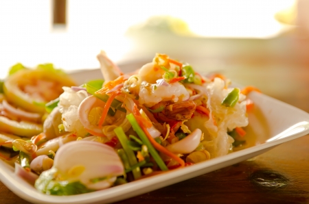 Thai seafood salad with squid over green leafの写真素材