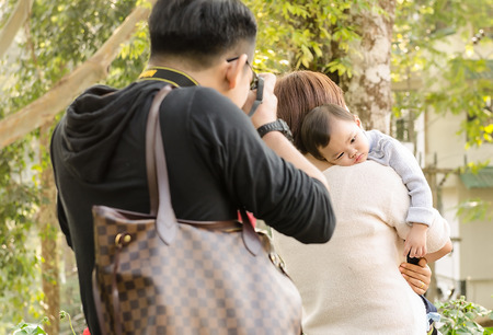 The child on a shoulder by mother to very happy. at garden in thailand.の写真素材