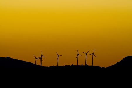 Wind turbine plant from distance at sundown with space for textの写真素材