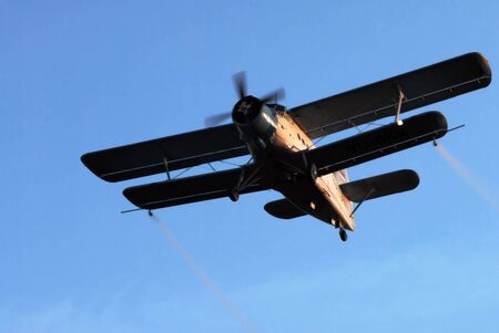 Airplane spraying, close up image against blue sky