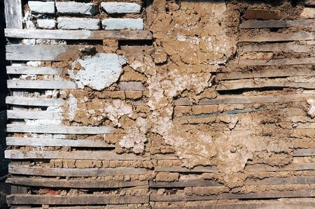 Close up image of old wall, bricks, mudd and wood are used for construction