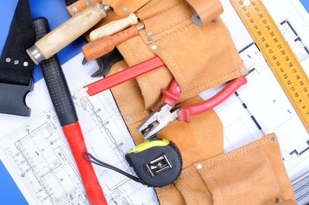 Different carpenter tools: saw, hummer, tape measure, level ruler, screwdriver are lying  upon the blueprints and drawingsの写真素材