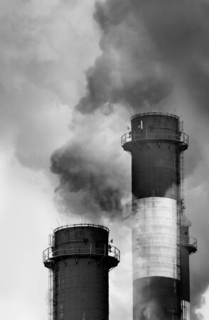 Close-up image of industrial chimneys releasing toxic smog clouds to atmosphereの写真素材