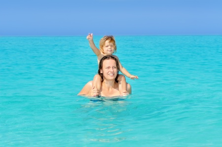 Happy child with her mother on the beach, summer vacation conceptの写真素材