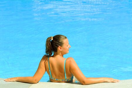 Young attractive female beauty relaxing in the swimming pool