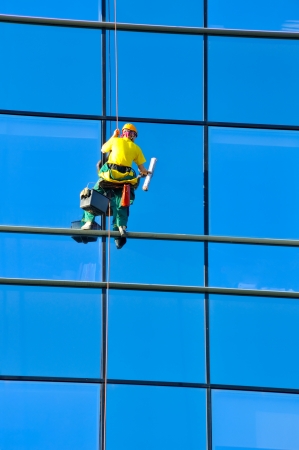 Washer wash the windows of modern skyscraper, high risk workの写真素材