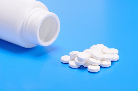 White capsules spilling from a prescription medicine bottle