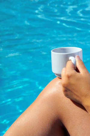 Closeup image of woman legs behind swimming pool, vacation concept