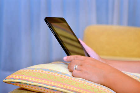 Close up image of woman hands holding and working on her tablet device