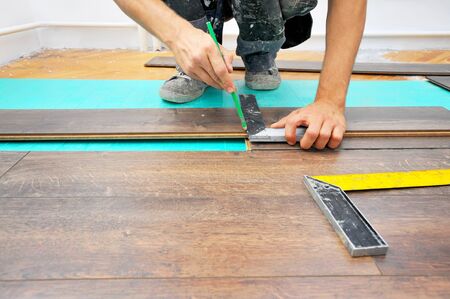 Worker carpenter doing laminate floor workの写真素材