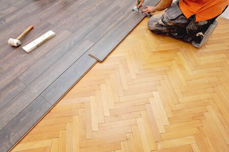 Real carpenter doing laminate floor workの写真素材