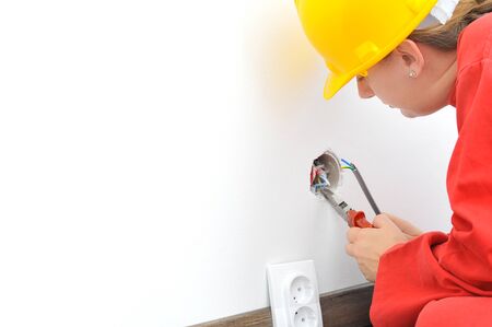Real female electrician fixing socket electricity problem