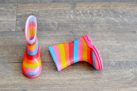 Pair of colorful children boots on the floorの写真素材