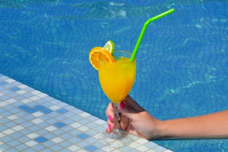 Real female beauty drinking cocktail near swimming pool, summer vacation concept