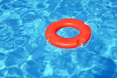 Colorful lifebuoy floating in swimming pool, summer vacation concept