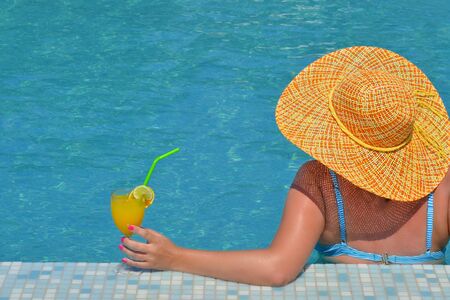 Real female beauty relaxing in swimming pool, summer vacation conceptの写真素材