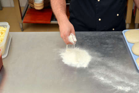 The process of making pizza, closeup hand of chef baker making pizza at kitchen.