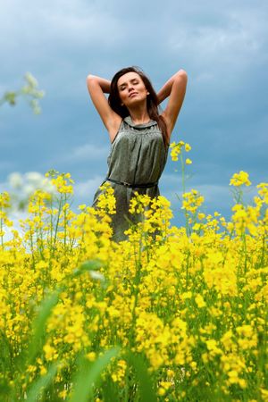 Young happy girl in yellow flowers, outdoor photo sessionの写真素材