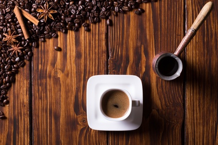 Still life with coffee beans, cup of coffee, turkish pot and spices on dark wooden background  Top view の写真素材