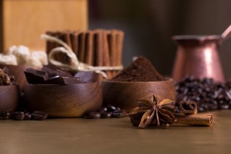 Wooden bowls with coffee beans, sugar, anise, chocolate  Cinnamon bunch, croissant and cup of coffee の写真素材