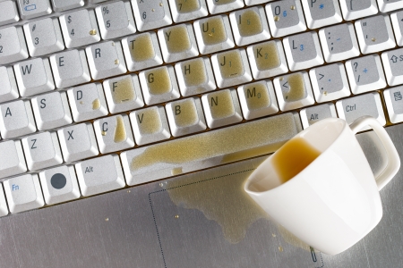 Coffee spilled on laptop keyboardの写真素材