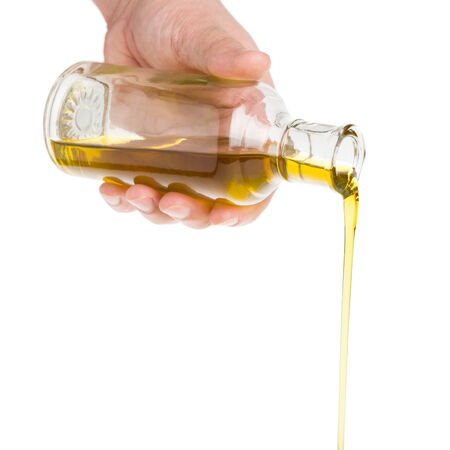 Male hand holding a bottle  Oil pouring from a bottle の写真素材