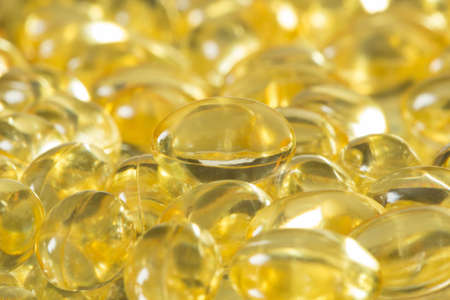 Background of fish oil omega 3 pills spilled from a bottle