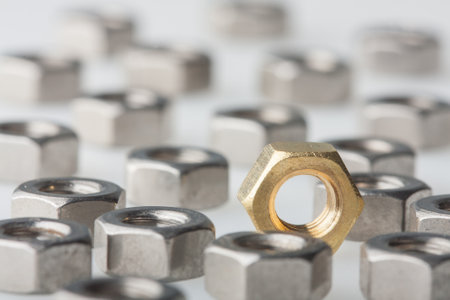 Metallic hex nuts layed out on a table, industrial backgroundの写真素材