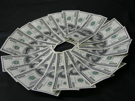 On a photo on a black background of a denomination of 100 dollars are laid out by circle. The photo...