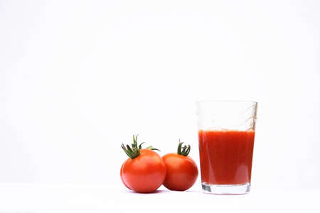 On a photo tomatoes and a glass of tomato juice.の写真素材