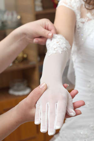 Friends help the bride to wear a glove. the bride's hand in a gloveの写真素材