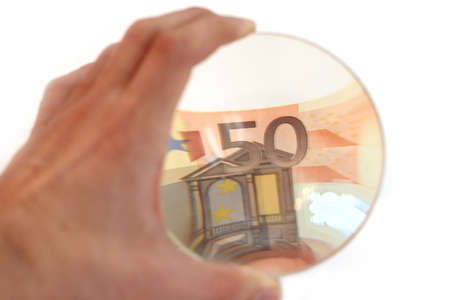 hand with the lens. considering the euro banknoteの写真素材